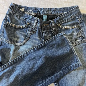 Jeans med snygga bakfickor  - Säljer dessa skitsnygga lågmidjade jeans med jättefina detaljer. Hör av dig vid frågor💕(de är ej skinnyjeans) midjemåttet är ca 39cm (håller dem i midjan på bilden då de är för stora för mig) 