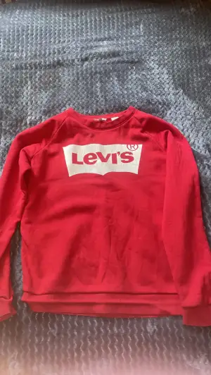 Röd Levi’s tröja, använder inte längre då den sticker ut så mycket. 