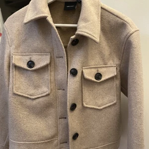 Kort kappa  - Den e beige. Kameran fick den o se lite gråaktig ut. Den e storlek 34 men passar 36 också 