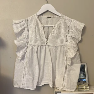 Vit blus med volang - Söt vit blus🤍🤍vet inte vilken storlek men skulle säga ungefär xs/s, passar båda!! Går fortfarande att köpa så hör av er om intresse❤️