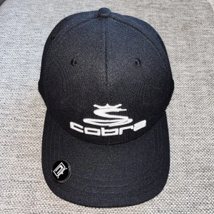COBRA Puma golf keps - Snygg svart golfkeps från Pumas egna golfmärke Cobra. Använd en gång. (Herr) Säljer åt min kille då den var något för stor på honom. 
