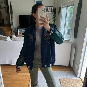 Jacka - Super cool bomberjack liknade för våren, sommaren och kan även användas på hösten eller bara som en overjacket 😌 Jackan är 100% silke i mörkgrön och mörkblå med unika mönster❣️ Den är i silkes material och i nyskick 😊 Jag har storlek S men funkar som M