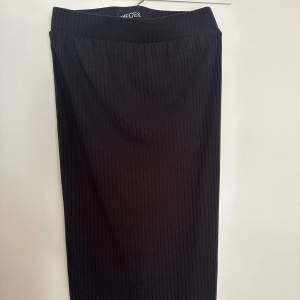 En svart kjol, med en slits lite under knät