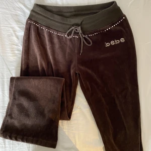 Bebe mjukis - Mjukisbyxor från Bebe, helt okej skick, tagg saknas och det finns ett litet hål på baksidan. Ganska korta i längden. Stretchig midja! Kan passa upp till M i midjan, det enda felet är att de är korta! Fråga inte om bilder på tack. Innerbenslängd: ca 64