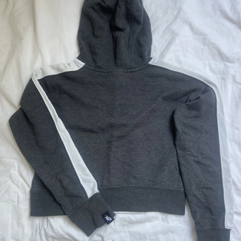 Mörkgrå Nike hoodie (magtröja? Vit text på framsidan o ingen text på baksidan. Vit sträck på ovansidan av armarna. Köpt för 400.. Hoodies.