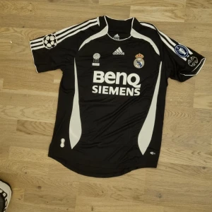 Real Madrid Ronaldo retro fotbollströja  - Säljer en real madrid tröja från Cristiano Ronaldos första säsong i Real Madrid.🇵🇹. Använd sparsamt och tvättad i 40° så allt teyck ör som nytt. Två champions league märken på ärmarna. Ronaldos namn på ryggen. Skriv pm om du har fler frågor.