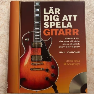 Bok: Lär dig att spela gitarr  - Boken ”Lär dig att spela gitarr - Handbok för dig som vill börja spela akustisk gitarr eller elgitarr” av Phil Capone   CDn finns kvar i boken och har aldrig spelats. Boken är som ny. 