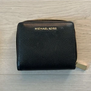 Michael kors plånbok  - Super snygg Michael Kors plånbok i svart med guld detaljer, toppen skick säljer då jag tyvärr inte längre får mycket användning av den:( 🖤 DMa för fler frågor/bilder!!!