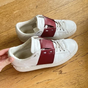 Valentino skor  - Säljer mina älskade Valentino Garavani Open Lace-Up Sneakers i den snyggaste röda färgen!🥰De är använda men fortfaras sjukt snygga! Lite stora i storleken så passar även upp mot 37,men också mig som har 36🙌🏽nypris ca 6000kr Box, dustbag, skosnören, intyg  