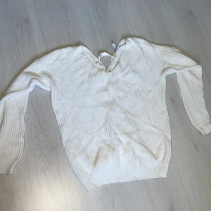 stickad tröja med kors i ryggen - aldrig använd, sthl XS och hårt material 