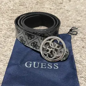 Svart/silver/grått guess skärp. Använt men är i fint skick. Det finns en skavank men inget som syns så. Ord pris runt 600-700 kr på hemsidan. Dustbag tillkommer och inga tydliga repor.