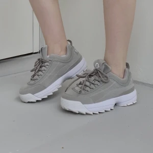 Grå/beige skor - Grå/beiga sneakers med vit och relativt hög sula i gott skick (använts fåtal gånger, är i originalkartong). Bekväma och rymliga, i storlek 36. 