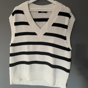 Stickad väst - En fin väst, snygg att ha över en vit skjorta. Väldigt sparsamt använd.