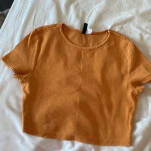 Orange Croptop  - Väldigt bra kvalitet. Inga fläckar eller hål etc… Den är knappt använd och är cirka 1 år gammal. 