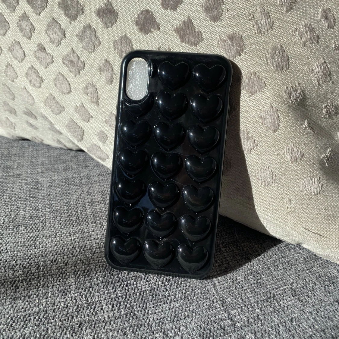 Svart mobilskal med hjärtan