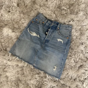 Jeanskjol - Jeanskjol från levis som tyvärr är alldeles för liten på mig. Strl 23, passar nog bäst på en 32/34