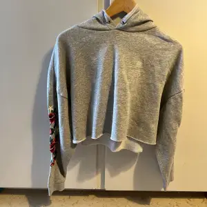 Grå croppad hoodie med broderade rosor