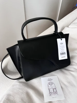 Oanvänd ATP Atelier väska - lapparna kvar - Säljer en jättefin oanvänd väska från Atp Atelier pga att den inte passar mig.  Lappen sitter kvar + väskan kommer i deras dustbag.  Modell: Arezzo Storlek: 18,5x34x10,5 cm Inköpt på Zoovillage, kvitto finns.