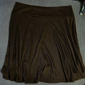 Svart kjol - Svart kjol ca 100cm i midjan. Ca 65cm lång, aldrig använd. Bomull.