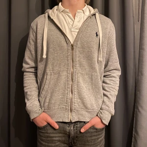 Ralph Lauren full zip Hoodie - Säljer nu en grå polo Ralph Lauren full zip hoodie. Väldigt bra skick men har tecken på användning 8/10, skriv för fler bilder. Nypris 2095kr mitt pris 349kr. Kolla gärna igenom min sida, paketpris kan alltid fixas och priserna är förhandlingsbara