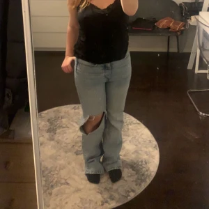 Bootcut jeans - Bootcut jeans med hål på ena benet. De är för tajta för mig men är sjukt snygga💕