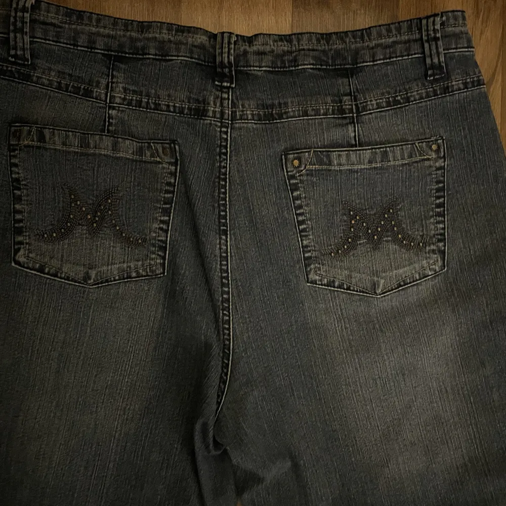 Blå bootcut jeans med stenar och broderier på fickorna. Jeans & Byxor.