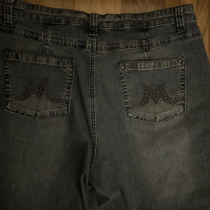 Blå bootcut jeans - Blå bootcut jeans med stenar och broderier på fickorna