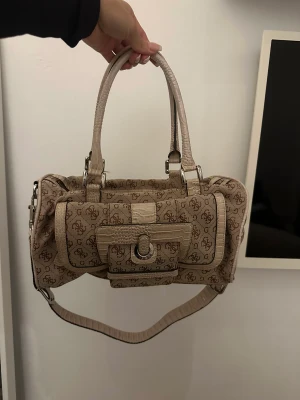 Guess Väska  - Säljer denna fina Guess väska, vintage. Används inte längre och är i bra skick. Säljer för 500kr 