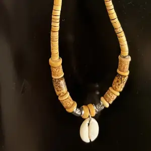 Halsband med träpärlor och en snäcka, har två av samma så säljer ett av dom.