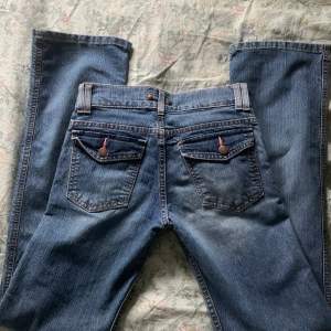 low waist jeans med knappar på fickorna bak 