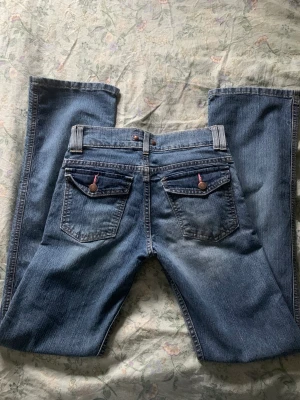 low waist jeans - low waist jeans med knappar på fickorna bak 