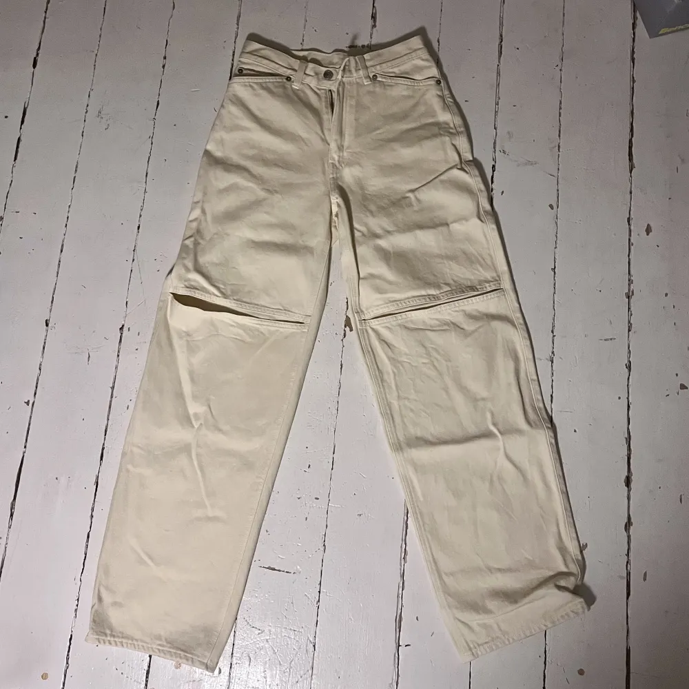 Coola beiga jeans från Weekday med ”hål” vid knäna. Modellen är rak och heter Brae Worker. Skulle säga att de motsvarar en 26” även om det står 25”. Obetydligt använda så väldigt bra skick! Jag är 167 på bild som referens.. Farkut & Housut.