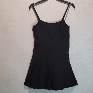 Klänning - Svart klänning. Schoolgirl-stil med axelband och dragkedja på sidan. Aldrig använd, endast provad. Nyskick. 