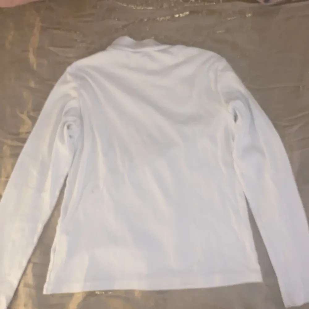 En lång ärmad vit tröja med en liten turtleneck som är perfekt till underlag på vintern. Tröjor & Koftor.