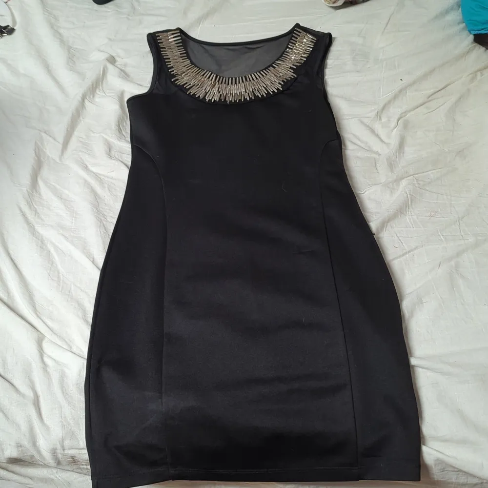 En svart klänning med silver detaljer som dock blivit lite missfärgade.. Klänningar.
