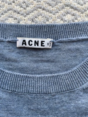 Acne tröja - Säljer denna tröja ifrån Acne Studios. I merinoull som känns som lövtunn Kashmir! Den har en jätteliten fläck på magen men inget som är synligt på håll