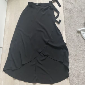 Kjol från amisu - Amisu, new yorker  Svart kjol med band i sidan samt knappar runt midjan  Strl 34/Xs 