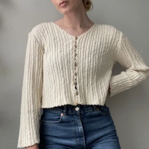 Crémevit kofta  - Crémevit tröja som får alldeles för lite användning! Inköpt i vintagebutik så i använt men bra skick. Något sliten vid knapparna som man ser på bilden, men  hel och fin i övrigt! Står storlek L i den men jag skulle snarare säga S.