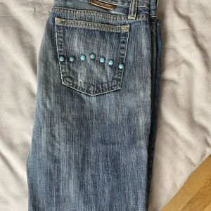 Lågmidjade jeans  - Jätte finna lågmidjade jeans men jag har ingen användning för dessa längre. Jätte finna knappar på. Men på ena fickan saknas en knapp jag har kvar den o kan sicka med den. 