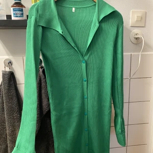 Långklänning med slits - Storlek S stor i storleken så passar perfekt en 38/M. Jättefin grön kläning som du knäpper, beroende på hur långt du väljer och knäppa kan du välja hur hög slitsen ska vara. Töjbar så sitter på väldigt skönt då den inte stramar åt.