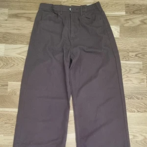 Utställda Jeans  - Bruna coola utställda jeans från H&M.  Anpassningsbar med resår i midjan och liten slits nedtill på benen. Köpta på barnavdelningen strlk 174 men som en S 