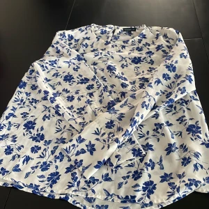 Söt bluse. - Gulligt bluse med blåa blommor. Stolek 38. 