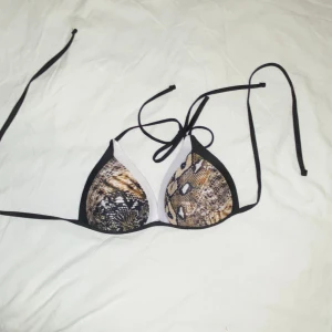 Bikini överdel - Säljer en bikini överdel. Står att den är L men jag som har M passade inte i den. Så skulle säga att det är mer storlek S. Har ormskinns mönster. Aldrig använd, endast testad. OBS: köparen står för frakten. (Annonsen finns ute på fler sidor)