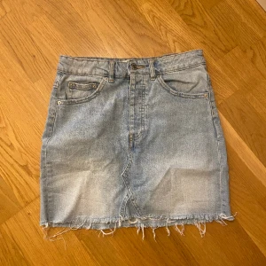 Ljusblå jeanskjol  - Fin jeanskjol i bra skick. Lite slitningar längst ner. Köparen står för frakt.