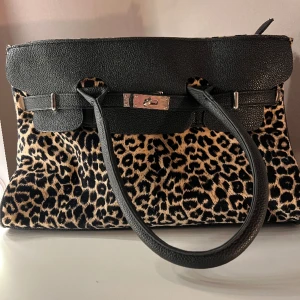 Väska retro - Hittade denna på loppis och har ej blivit använd tyvärr. Birkin-inspirerad och är hel och ren, vet ej vad det är för märke riktigt. Mått:25cm hög, 36cm bred, 13cm bred i botten.