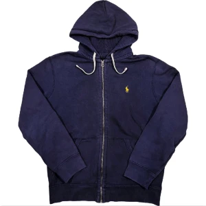 Ralph Lauren Zip-Up Hoodie - Marinblå huvtröja med dragkedja från Ralph Lauren, tröjan saknar lappar men är äkta. Storlek M, ställ gärna frågor!😊
