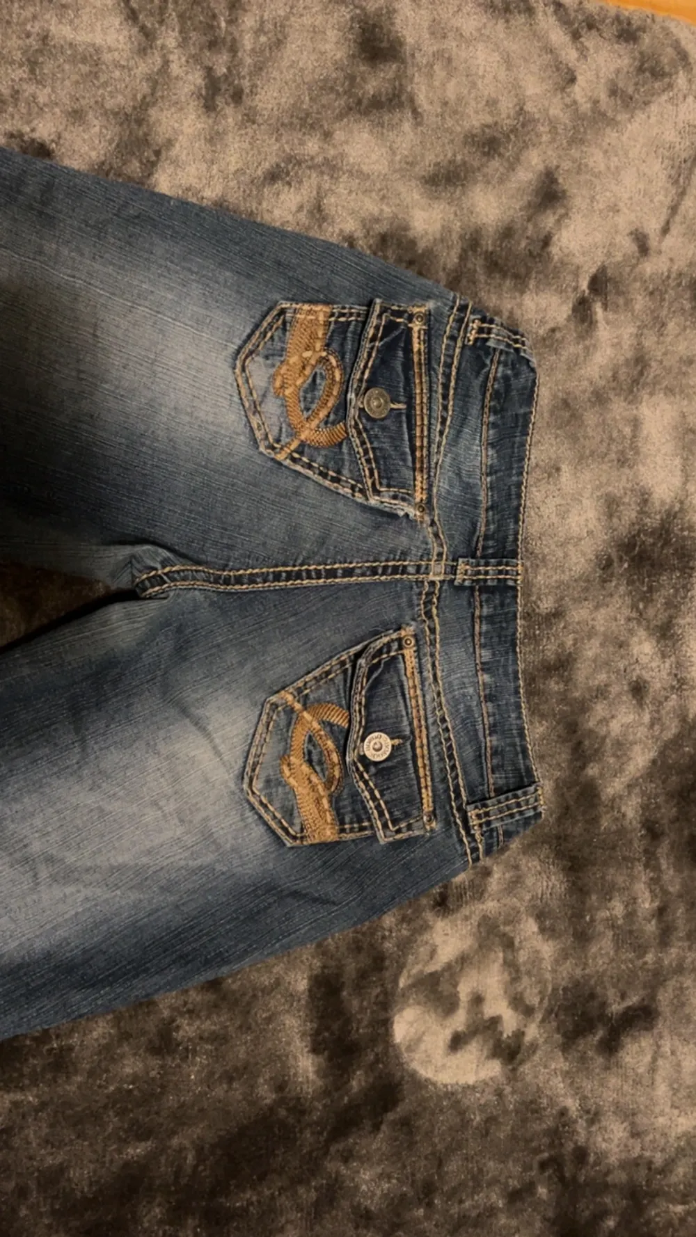 Snygga lågmidjade jeans i bootcut/flare modell med fina beiga detaljer!! Kan absolut skicka fler bilder om behövs!🫶 Innberbenslängden: 80 cm Midjemåttet: 38 cm (tvärsöver). Jeans & Byxor.