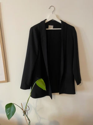 Glittrig kavaj - Härligt glittrig kavaj, utan knappar.