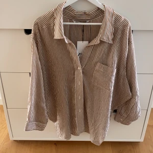 Skjorta - Randig oversized skjorta🤎🤍🤎 brun och vit! Aldrig använd. Nypris 399kr