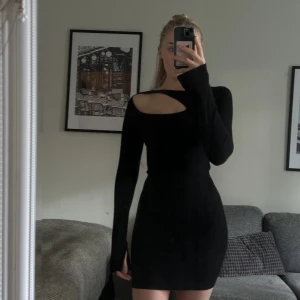 Svart klänning - Ribbad miniklänning med öppning vid ärmslut, aldrig använd. Nypris 699kr